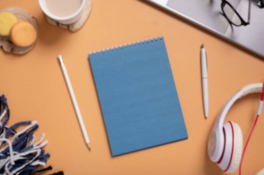 Dizüstü bilgisayarı, ekose ve kulaklığı olan bir not defteri. İş veya eğitim metni için boş not.