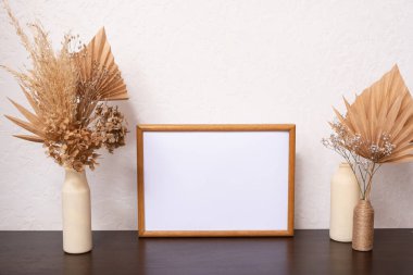 Boş ahşap çerçeve modeli, kurumuş yaprak ve beyaz arka planda vazolar, iç dekorasyon, ev tasarımı. Sanat konsepti. Boşluğu kopyala.