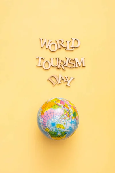 World Tourism Day Text Wooden Letters Yellow Background Globe Vertical — 스톡 사진
