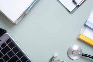 Stethoscope, laptop and folders with documents, pills and syringes top view. Medical flat lay on colored background with copy space.