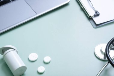 Haplar, bilgisayarlı steteskop ve doktorun iş yerinde tablet. Boşluğu kopyala.