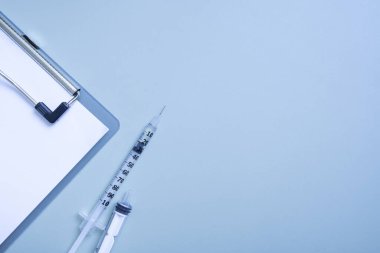 Şırıngalar ve renkli arka planda bir tablet. Kopyalama alanı olan tıbbi arkaplan.