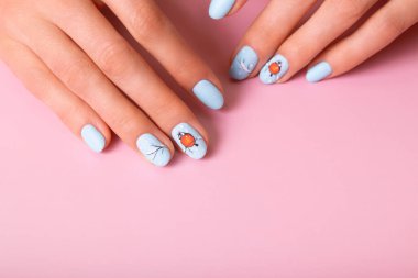 Kış kar manikürlü kadın eller. Pembe arka plandaki mat üstünün altında çıkartmalar var..