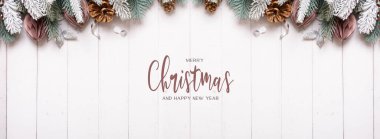 Mutlu Noeller ve Mutlu Yıllar yazılı mesaj pankartı. Çam, koni, tahta arka planda topların düz kompozisyonu..