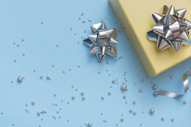 Yılbaşı ve yeni yıl hediyesi kutuları, inciler ve fiyonklar mavi arka planda yatıyordu..