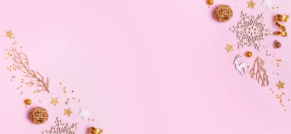 Christmas banner with minimalistic composition on pink background with golden decor and copy space.