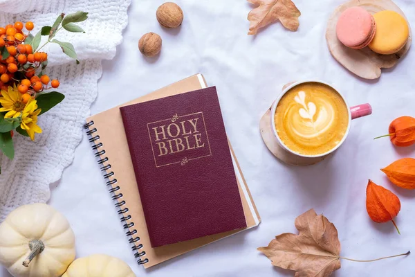 Holy Bible with cup of coffee and autumn cozy decor top view. Bible study fall concept.