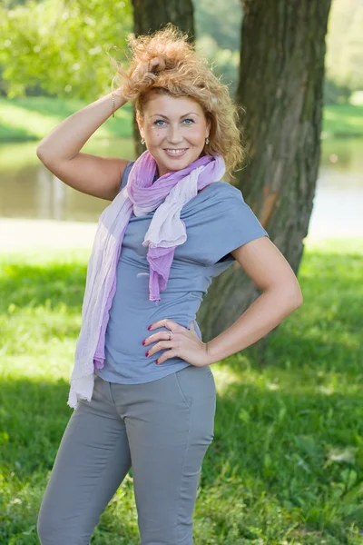 Vacker kvinna promenader i parken. solig dag — Stockfoto