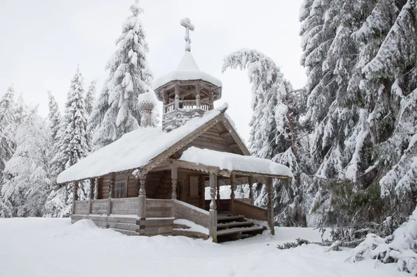 Capilla de madera en un bosque nevado. Norte invierno . — Foto de Stock