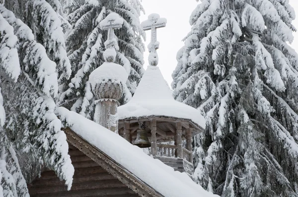 Capilla de madera en un bosque nevado. Norte invierno . — Foto de Stock