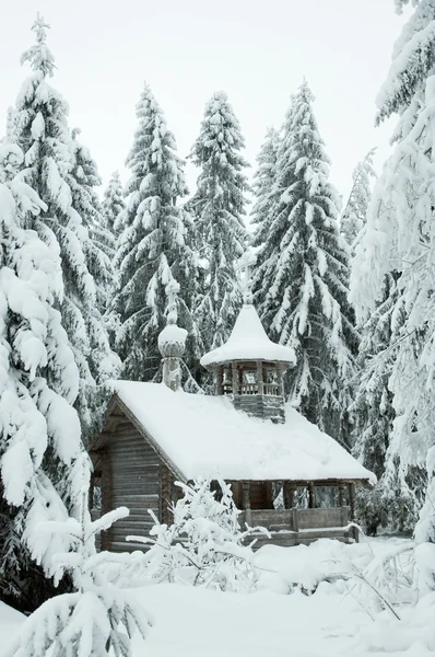 Houten kapel in een besneeuwde forest. winter noorden. Stockfoto