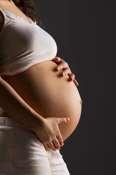 Pregnant woman caressing her belly — Stock Photo, Image