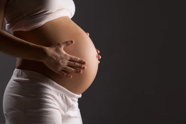 Pregnant woman caressing her belly — Stock Photo, Image