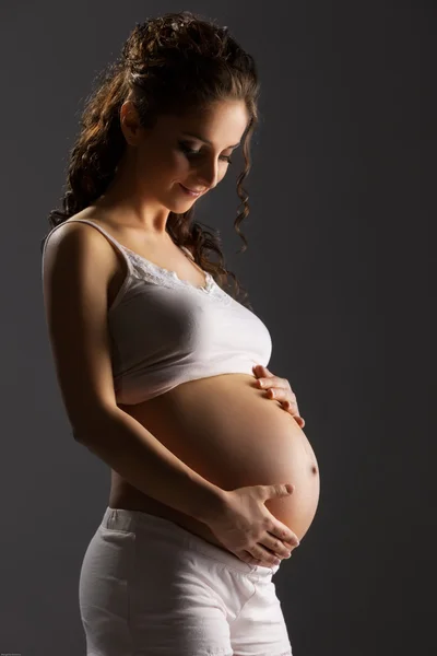 Беременная женщина ласкает живот — стоковое фото