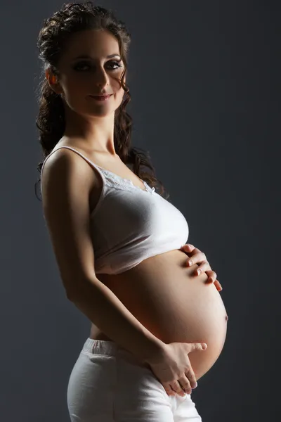 Gravid kvinna smeker magen — Stockfoto