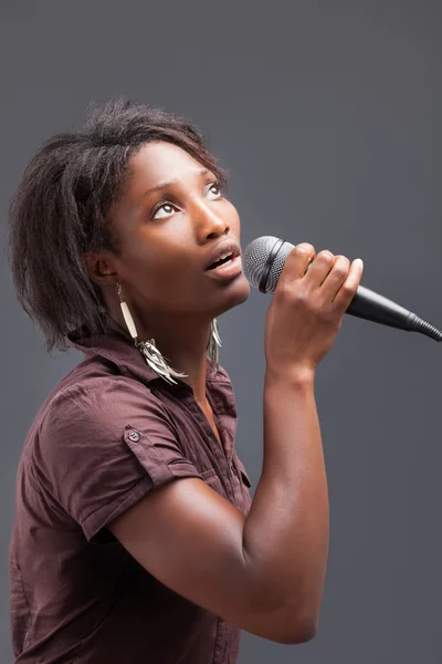 Mulher negra cantando no microfone — Fotografia de Stock