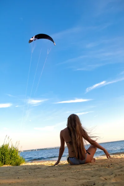 Aantrekkelijk meisje, zittend op het zand. — Stockfoto