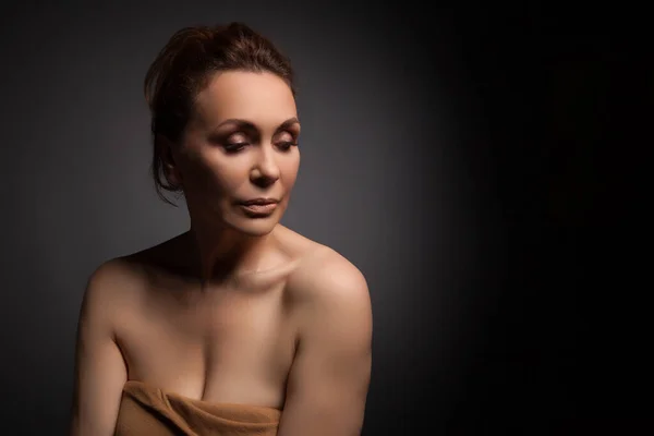 Portrait of a sensual fifty year old woman on grey studio background — Stock Photo, Image