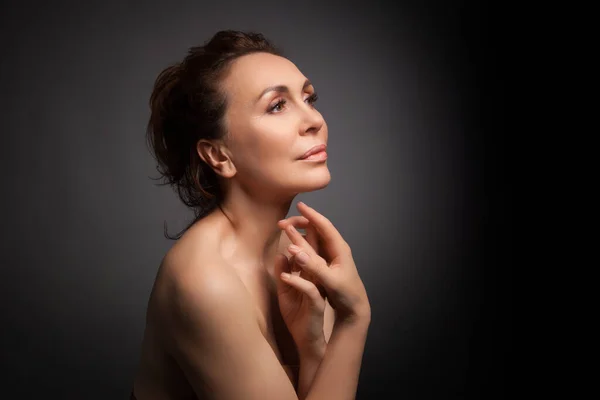 Portrait of a sensual fifty year old woman on grey studio background — Stock Photo, Image