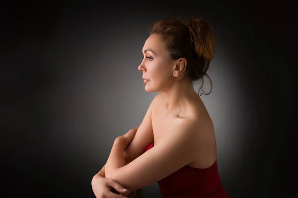 Portrait of a sensual fifty year old woman on grey studio background — Stock Photo, Image