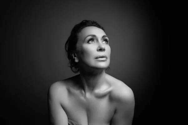 Portrait d'une femme sensuelle de cinquante ans sur fond de studio gris. Plan monochrome . — Photo