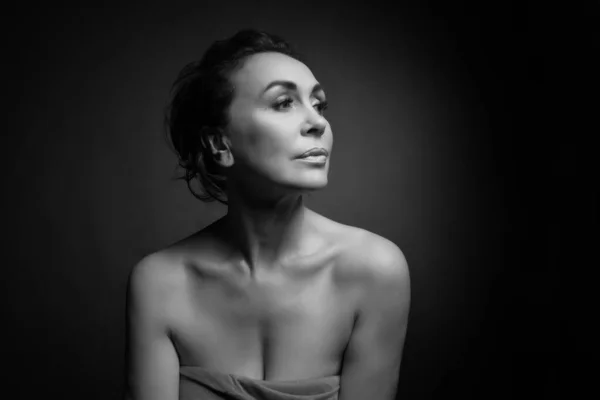 Retrato de una sensual mujer de cincuenta años sobre fondo gris del estudio. Monocromo tiro . — Foto de Stock