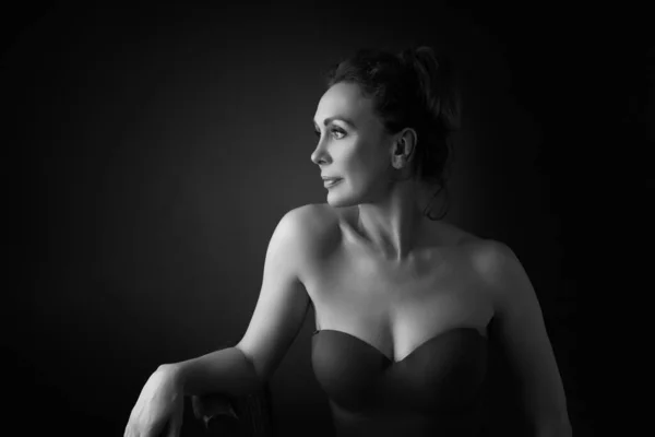 Portrait d'une femme sensuelle de cinquante ans sur fond de studio gris. Plan monochrome . — Photo