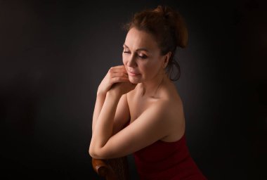 Gri stüdyo arka plan üzerinde şehvetli elli yaşındaki bir kadının Klasik headshot portre