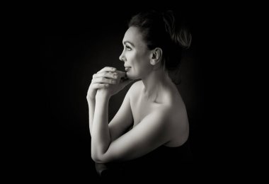 Gri stüdyo arka planında 50 yaşında şehvetli bir kadının klasik portresi. Tek renkli çekim..