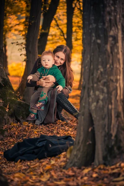 Mãe com filho na floresta de outono — Fotografia de Stock