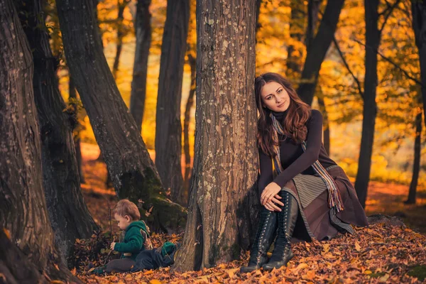 Madre con hijo en bosque de otoño — Foto de Stock