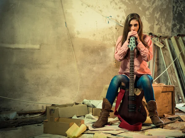 Femme avec guitare dans une pièce endommagée — Photo