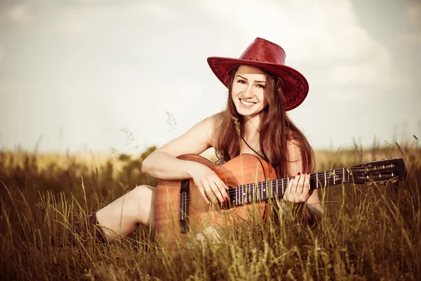 Vrouw spelen gitaar op lente weide — Stockfoto