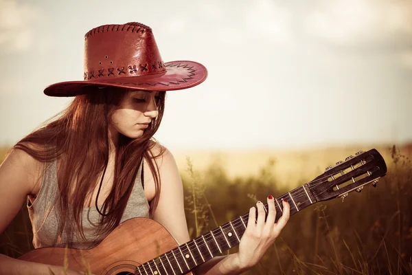 Femme jouer de la guitare au pré de printemps — Photo