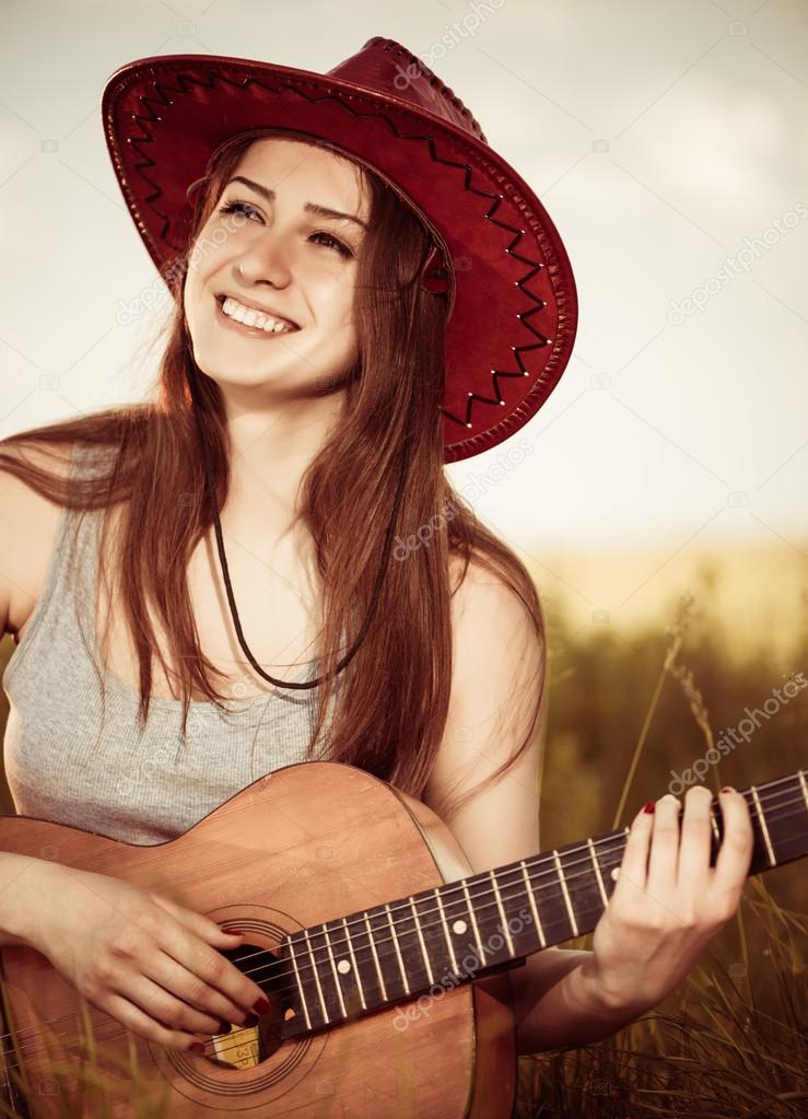 Woman play guitar at spring meadow