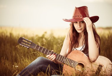 Woman with guitar at spring grass clipart