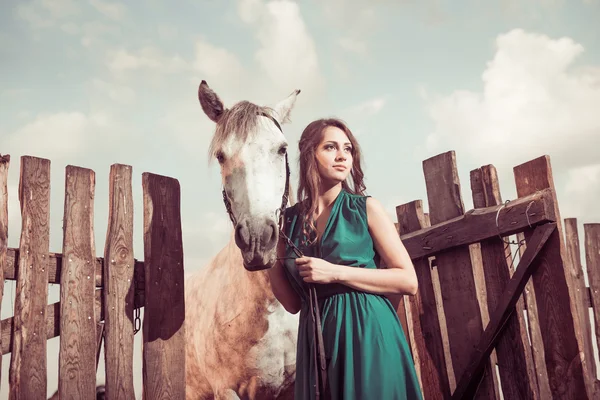 Kvinna på gården solnedgången med vita hästen — Stockfoto