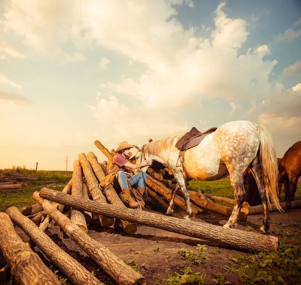 Καουμπόη με το άσπρο άλογο στο αγρόκτημα ξυλείες — Stock fotografie