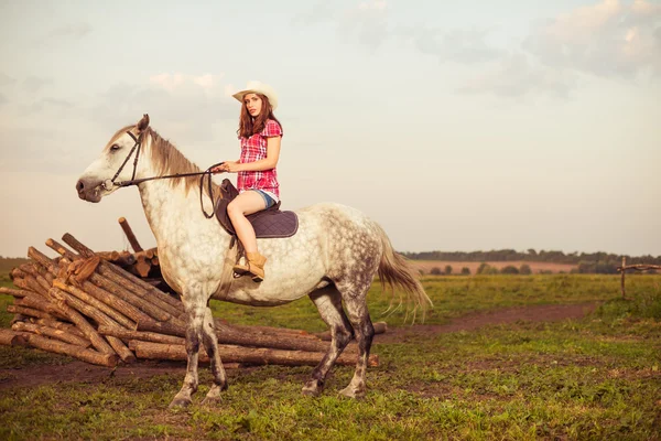 Jonge veedrijfster rijdt een paard — Stockfoto