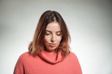 Stüdyo arka planında pembe kazaklı genç kadın portresi