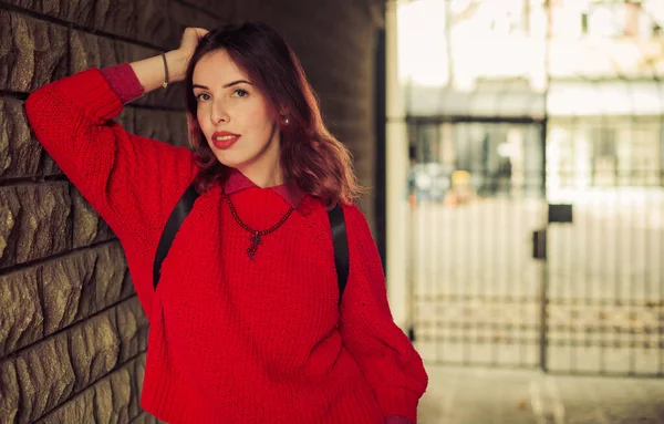秋天城市街道上身穿红色毛衣的年轻女子 — 图库照片