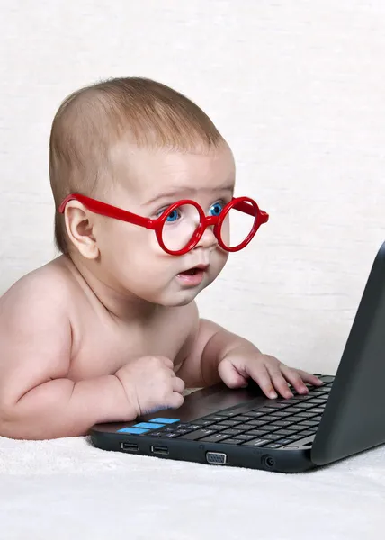 Chico divertido en las gafas con un netbook — Foto de Stock