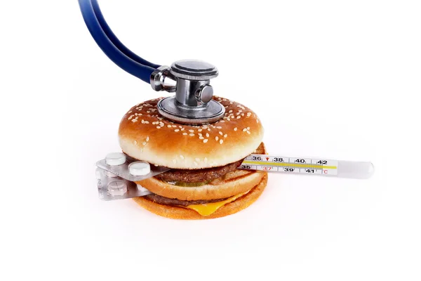 Hamburger with the pill, a thermometer and stethoscope — Stock Photo, Image