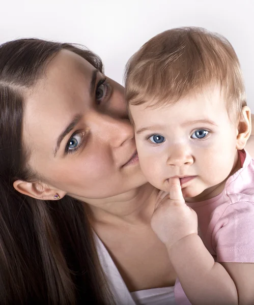 A happy young mother with a beautiful baby in her arms — Stock Photo, Image