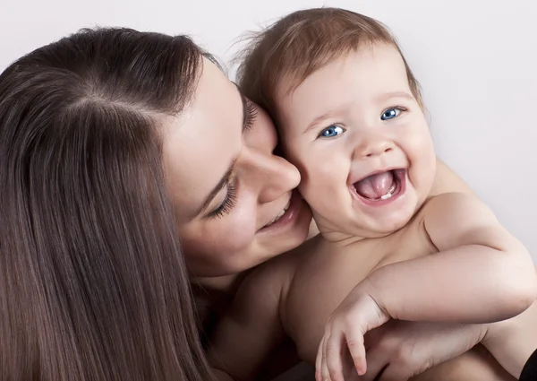 A happy young mother with a beautiful baby in her arms — Stock Photo, Image