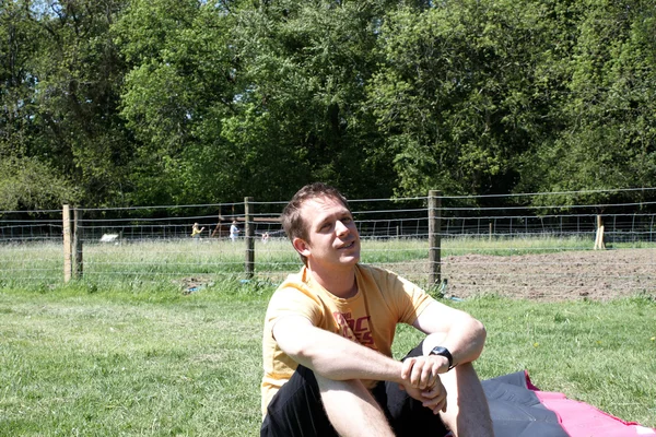 草の上に座っている男 — ストック写真
