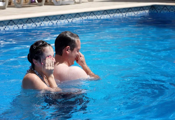 Um casal se divertindo em uma piscina — Fotografia de Stock