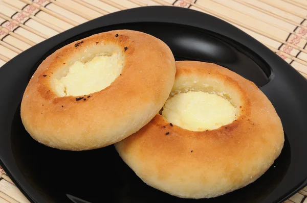 Two curd tarts on a black plate — Stock Photo, Image