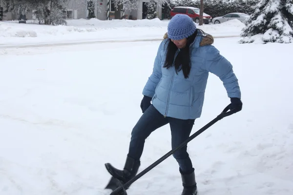 Señora paleando nieve — Foto de Stock