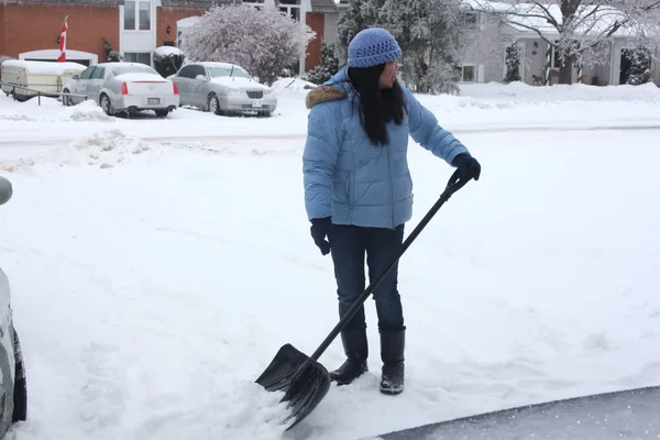 Señora paleando nieve — Foto de Stock